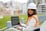 Engineer using a laptop at an outdoor construction site.