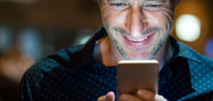 Man Smiling at Cell Phone | Alpha Software