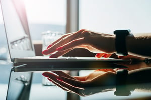 Hands Shown Typing on a Laptop Sitting on a Table | Alpha Software