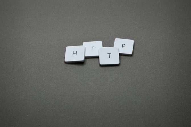 White letter tiles spelling "HTTP" arranged on gray textured surface