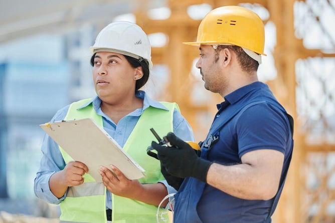 Workers reviewing paper documents, highlighting the inefficiency of manual data collection in industrial facilities.