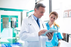 Two doctors reviewing data on a tablet