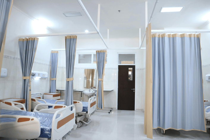 A modern hospital ICU room with multiple patient beds.