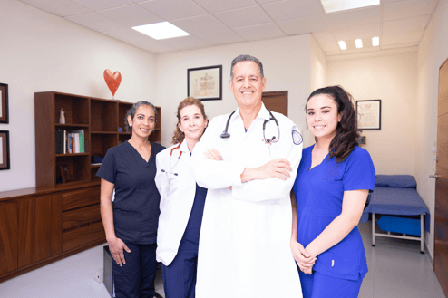 Healthcare team of doctors and nurses standing together in a hospital office.