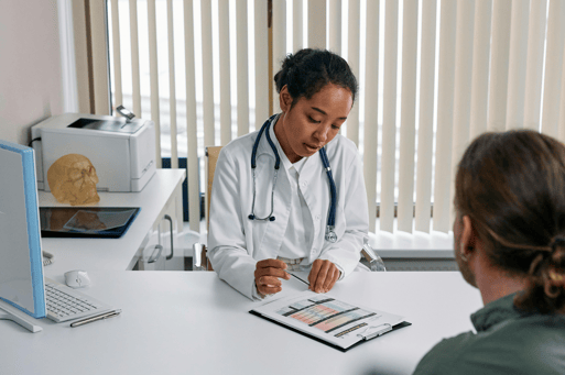 Doctor consulting with a patient across the desk in a medical office.