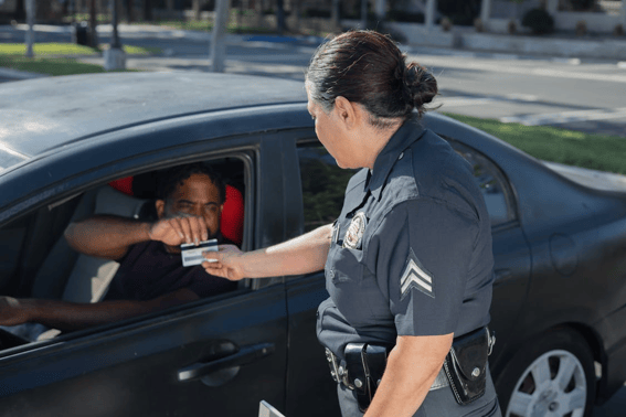 Man giving his driver's license to the policewoman.