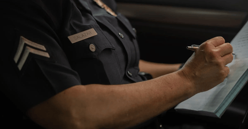 Police officer taking notes on a book.