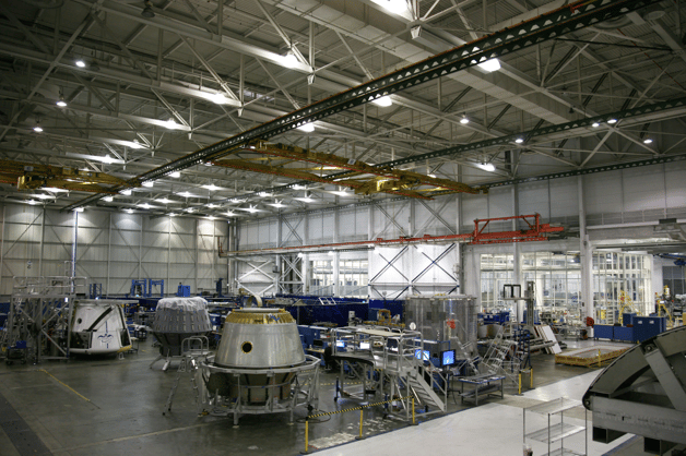 Advanced manufacturing floor featuring large-scale assembly and integrated digital workstations for real-time production monitoring.