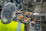 Worker in a hairnet and high-visibility vest inspecting packaged dates on a production line