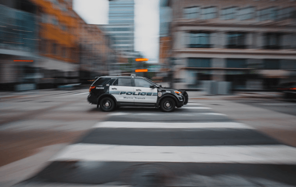 Black and white police car on the road during daytime. 