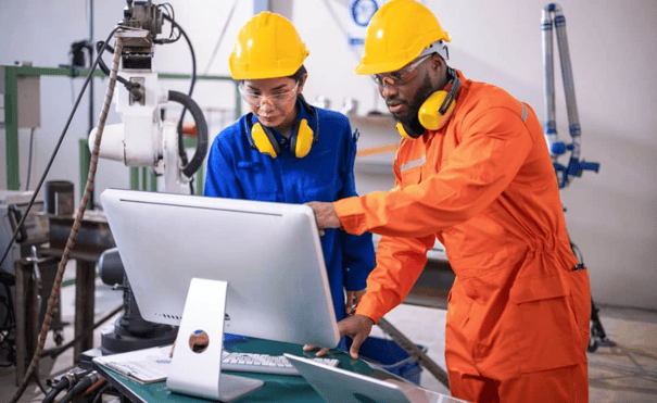 Manufacturing personnel taking a look at an inventory monitor screen.