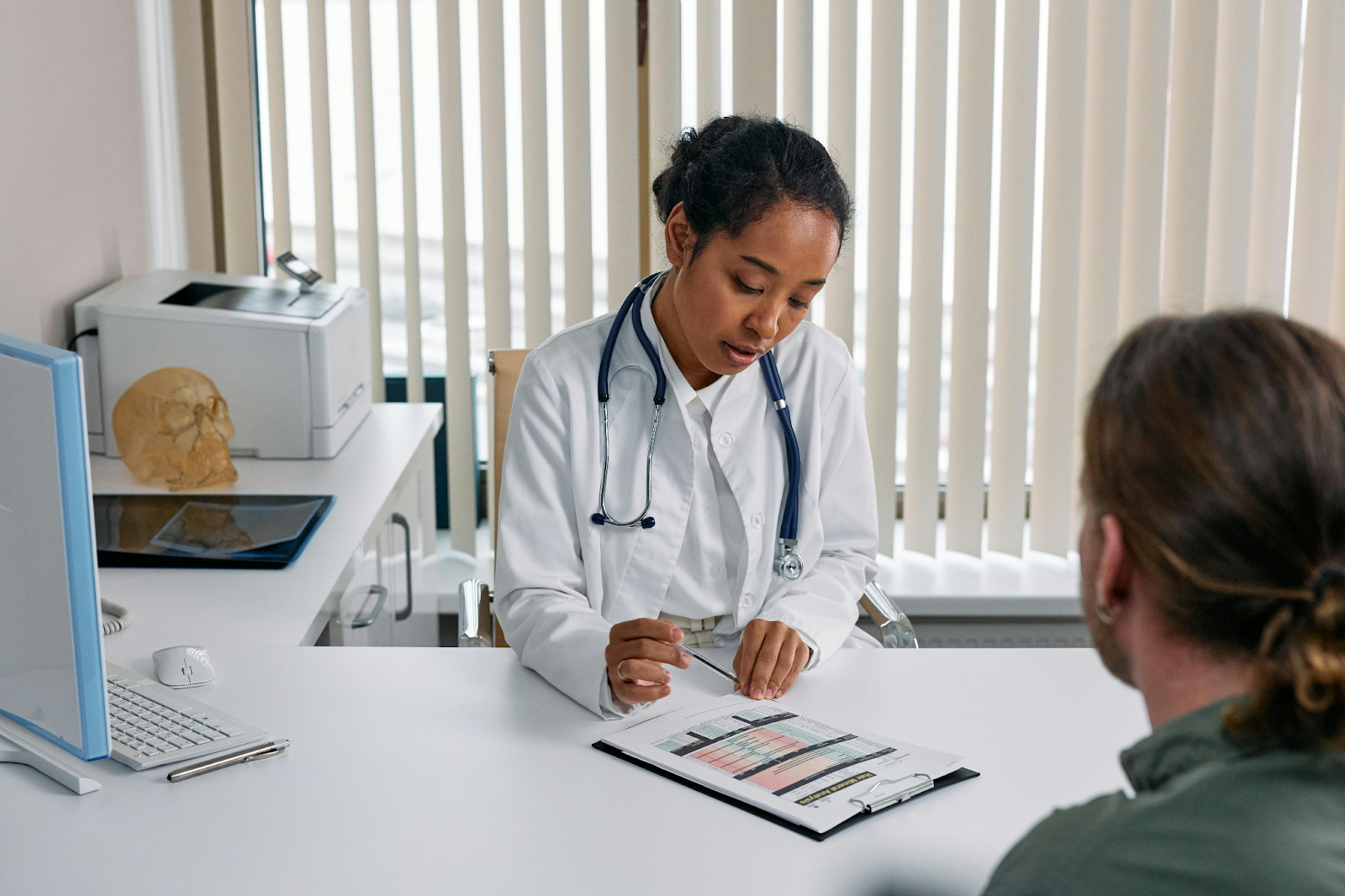 Doctor consulting with a patient across the desk in a medical office