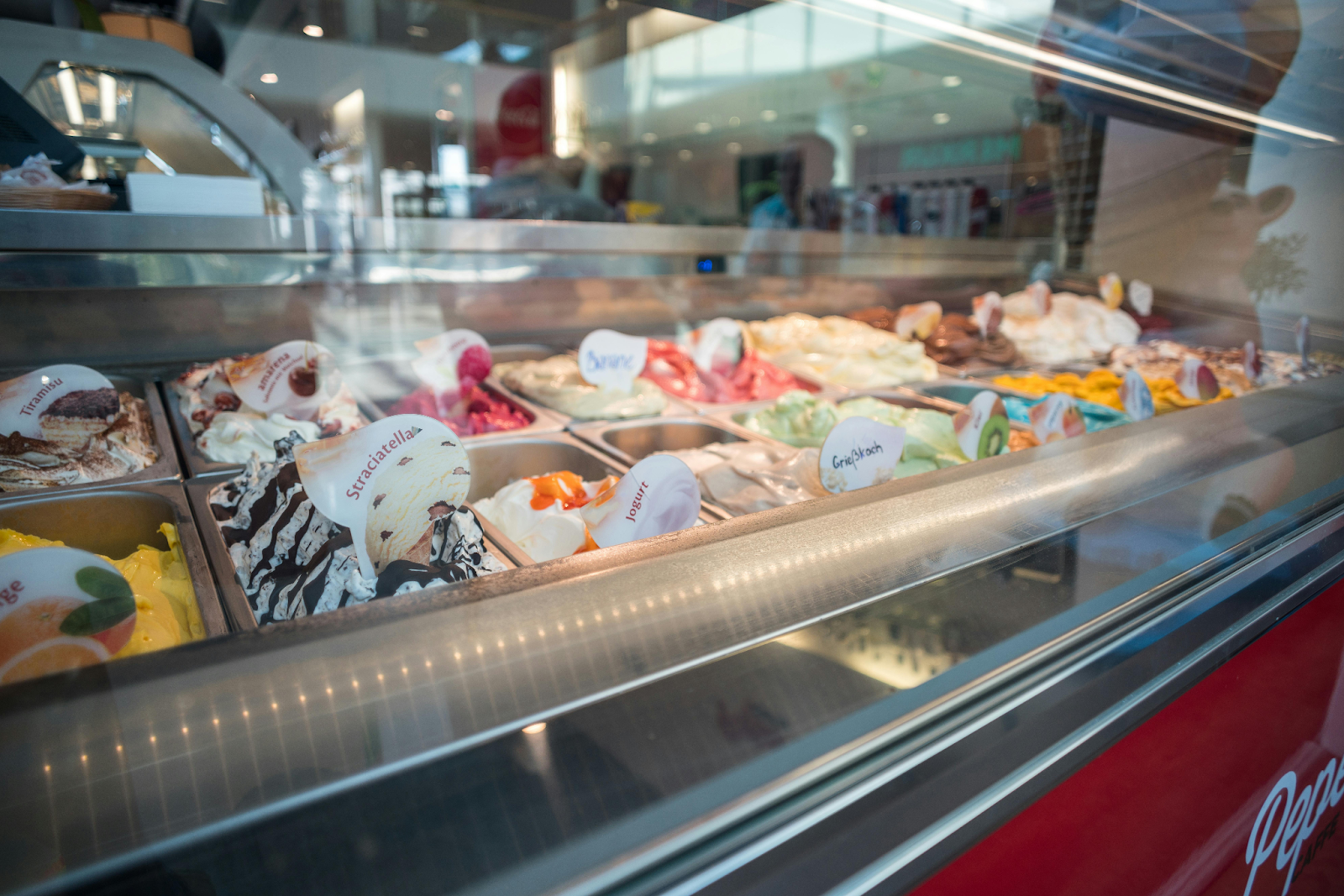 A commercial freezer displaying different ice cream flavors