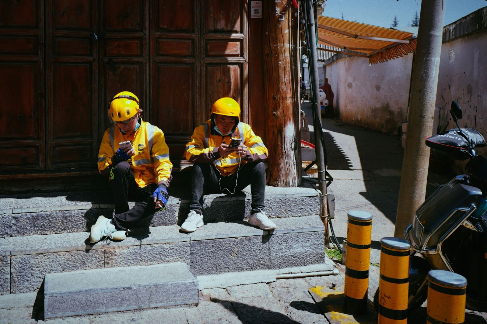 Construction workers using mobile phones on-site, symbolizing the use of digital tools and checklists for building construction inspections.